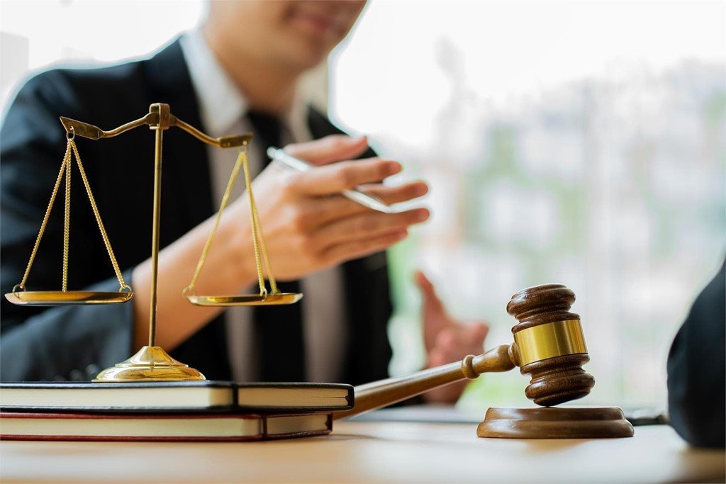 Balanza de la justicia y mazo sobre los códigos del despacho